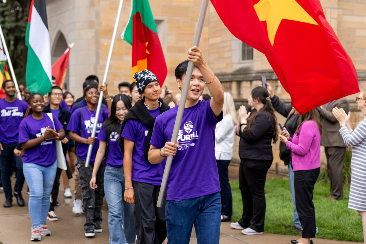 Students marching through the arches