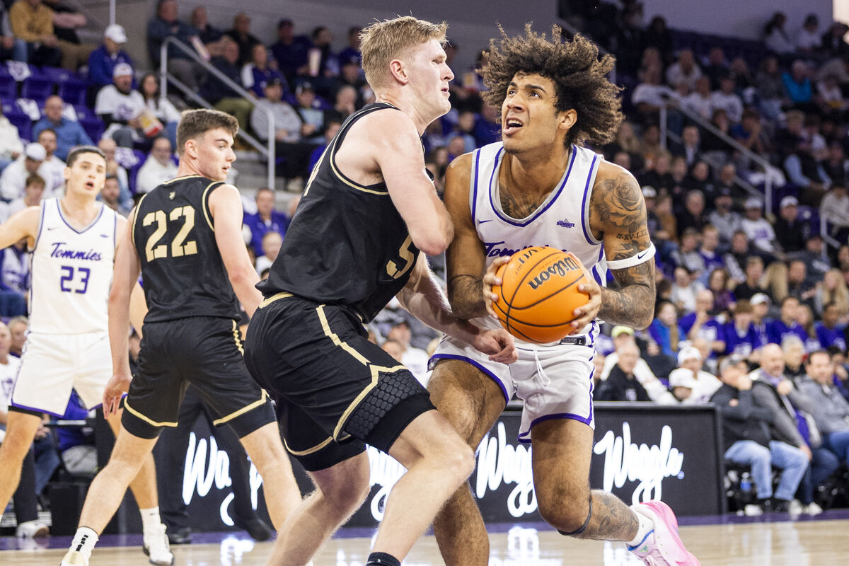 mens basketball player drives towards the net