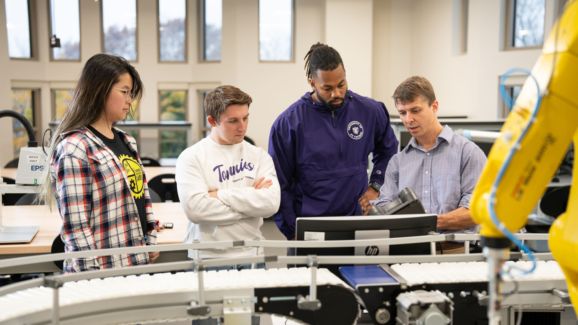 Students and Professor Thomas Secord examine equipment in the Blattner Robotics and Automation Lab