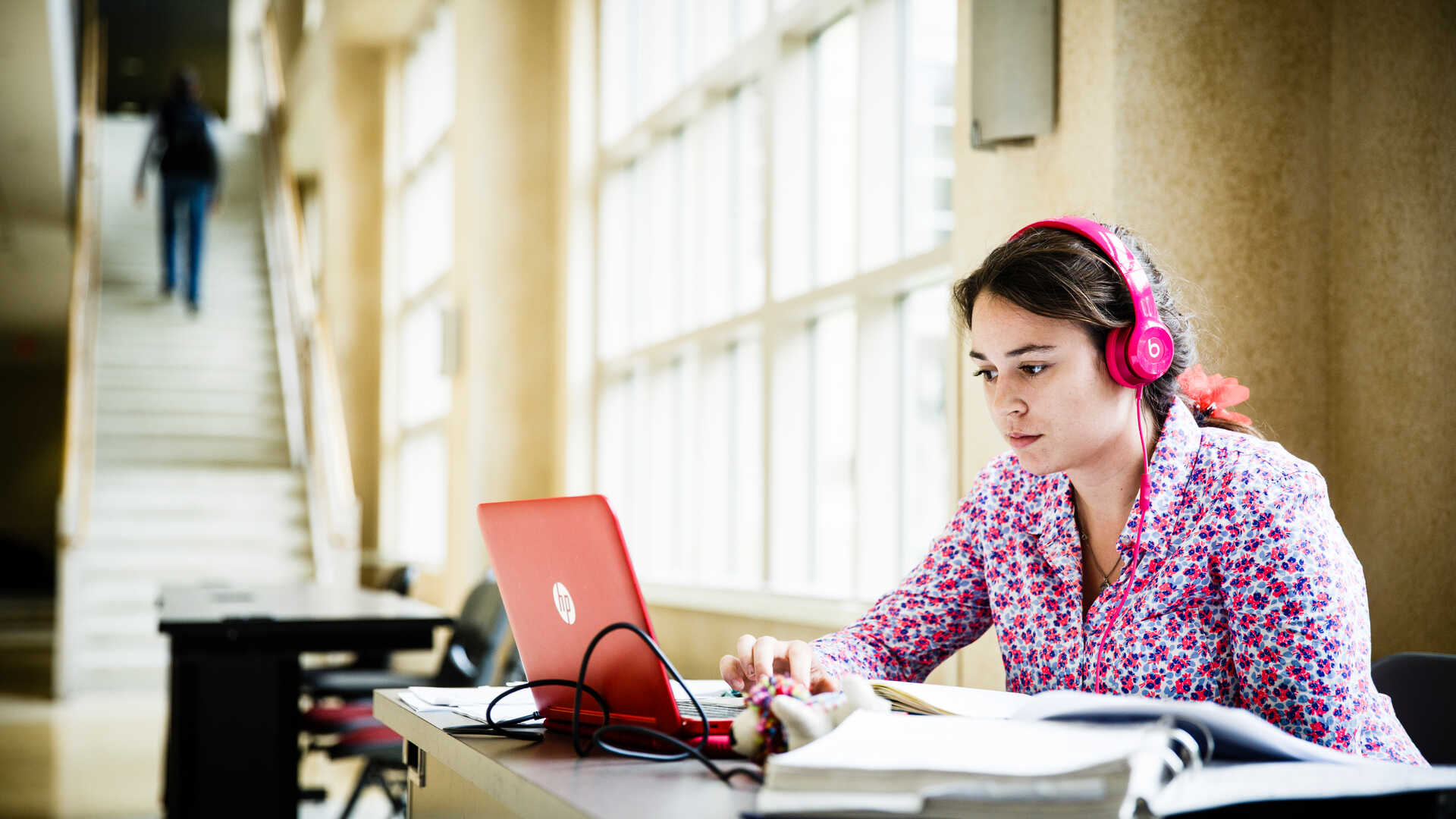 woman wearing headphones looking at computer