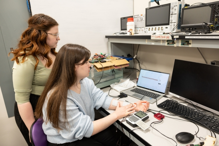 two students work on a biomedical device in an engineering lab