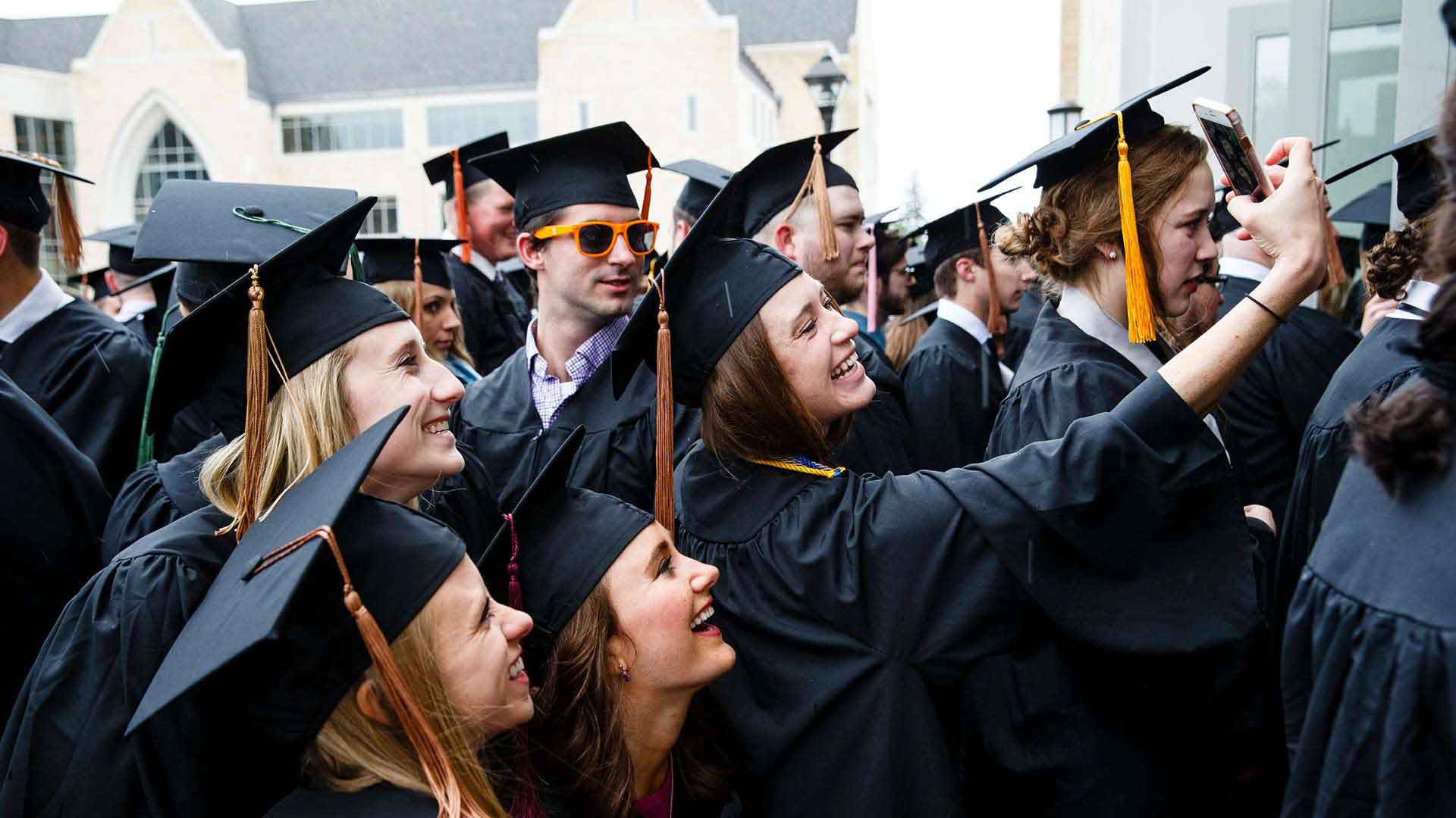 Seniors take a selfie together at an Undergraduate Commencement ceremony