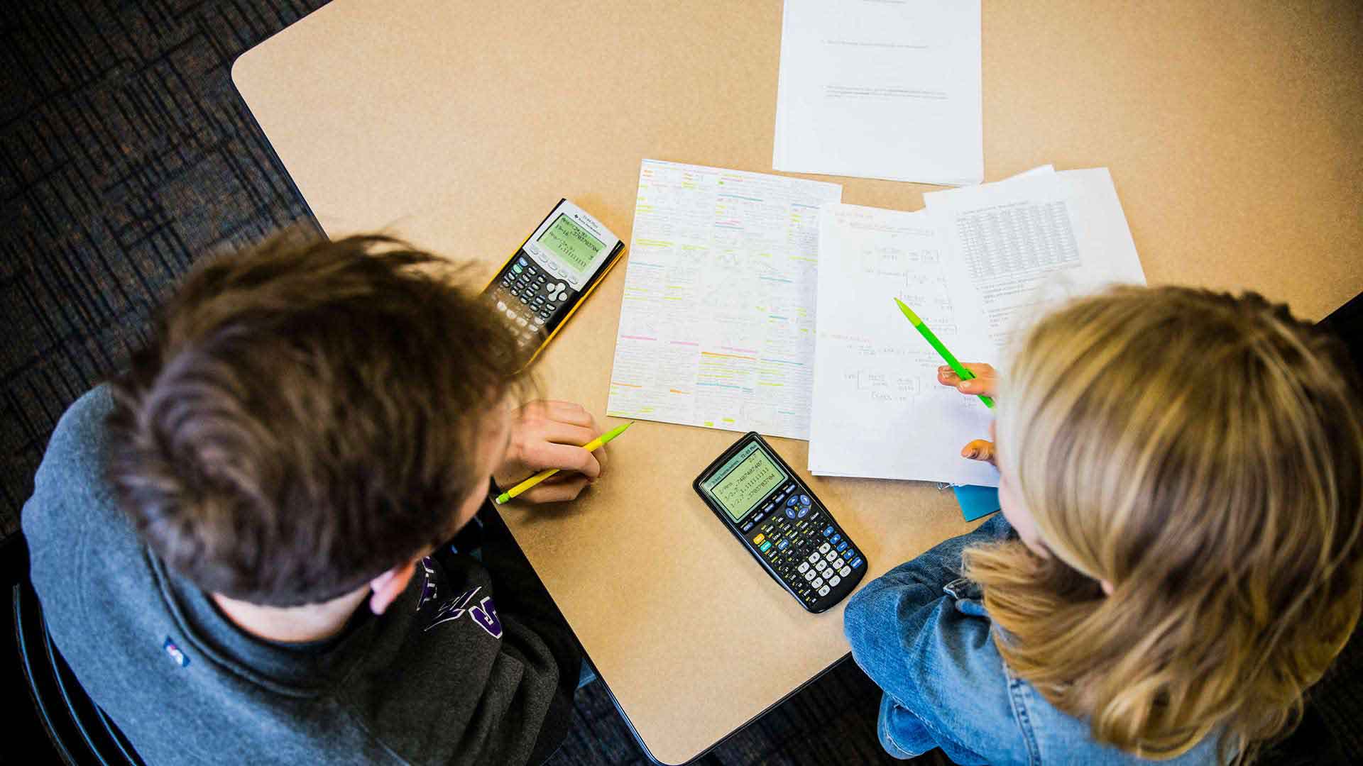 Student talk over study materials and a calculator
