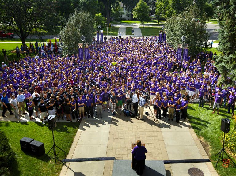 students wearing purple gathered outside