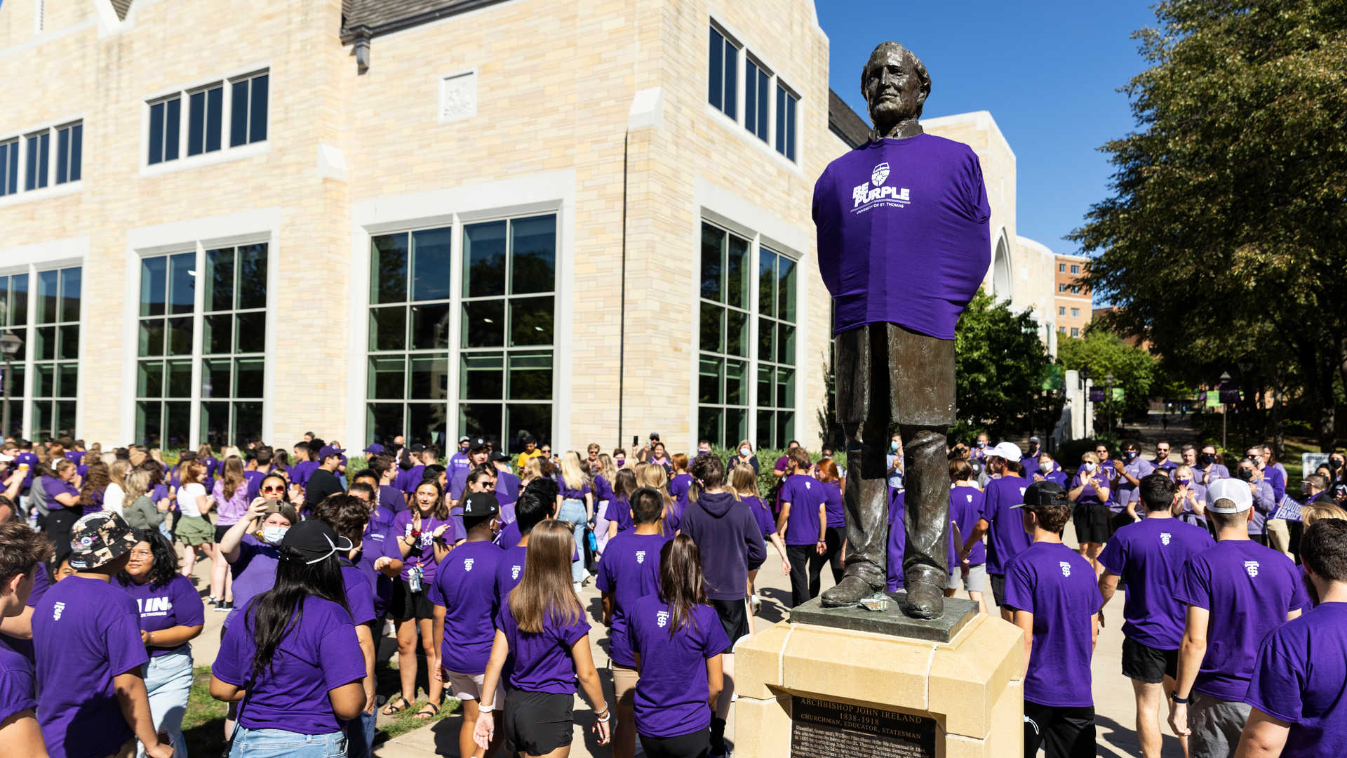 Undergraduate students in purple t-shirts around the John Ireland statue 