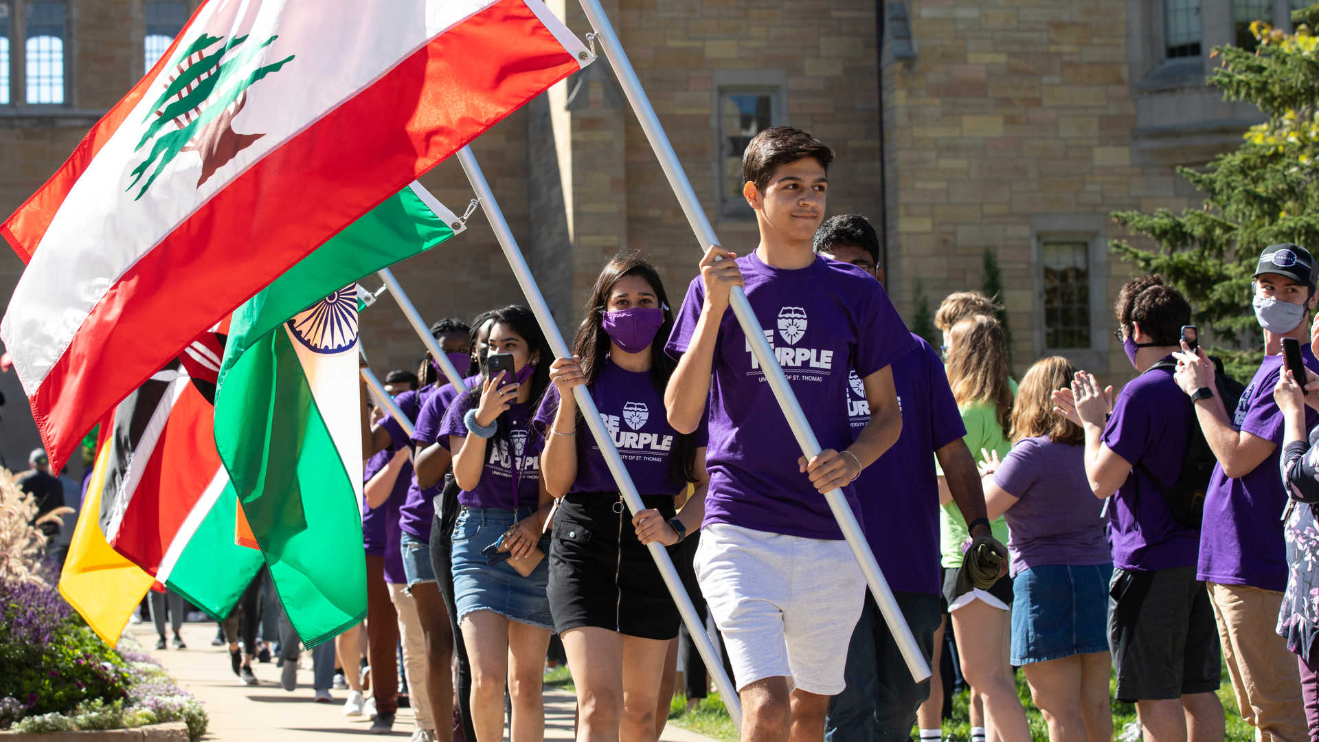 Students carry flags representing their country during March through the Arches. 
