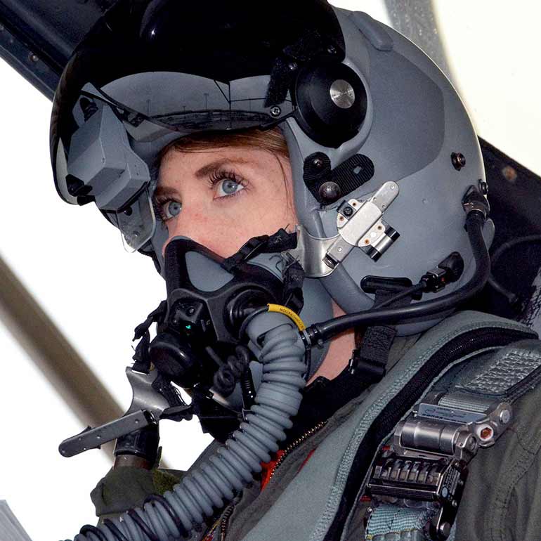 Capt. Michelle Curran in the cockpit of a jet, wearing a helmet.