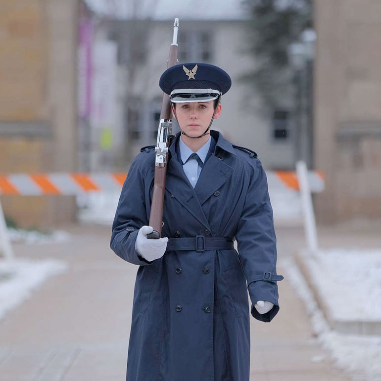 Ellise Brennan walking through campus in uniform.