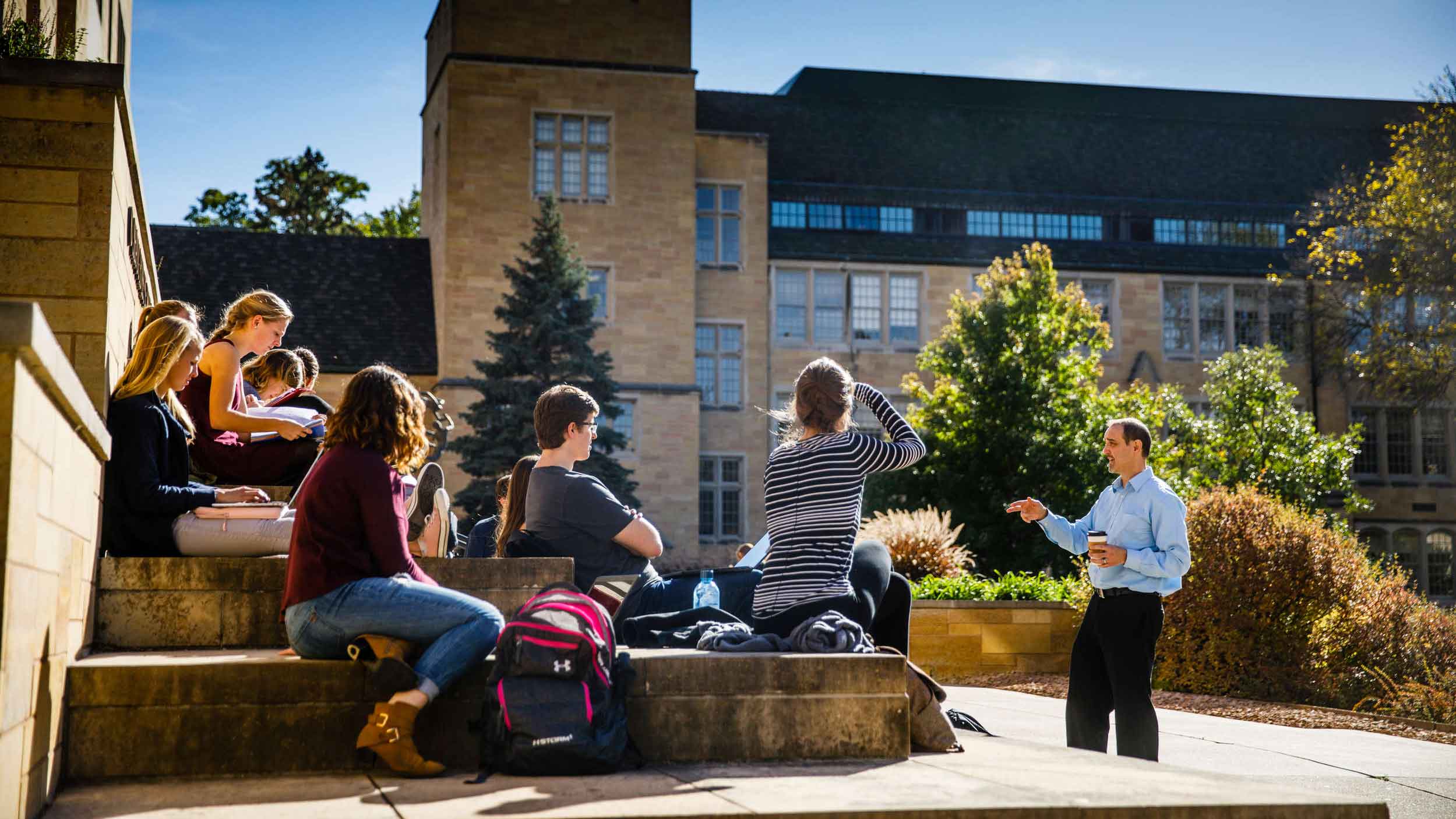 Professor teaches class outside on a sunny day