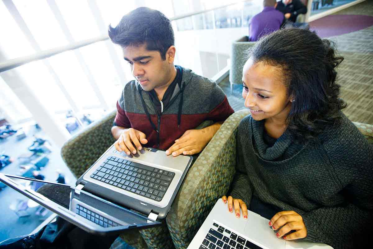 Students smile as they work on their laptops on the second floor Campus Way of the Anderson Student Center October 13, 2015. 