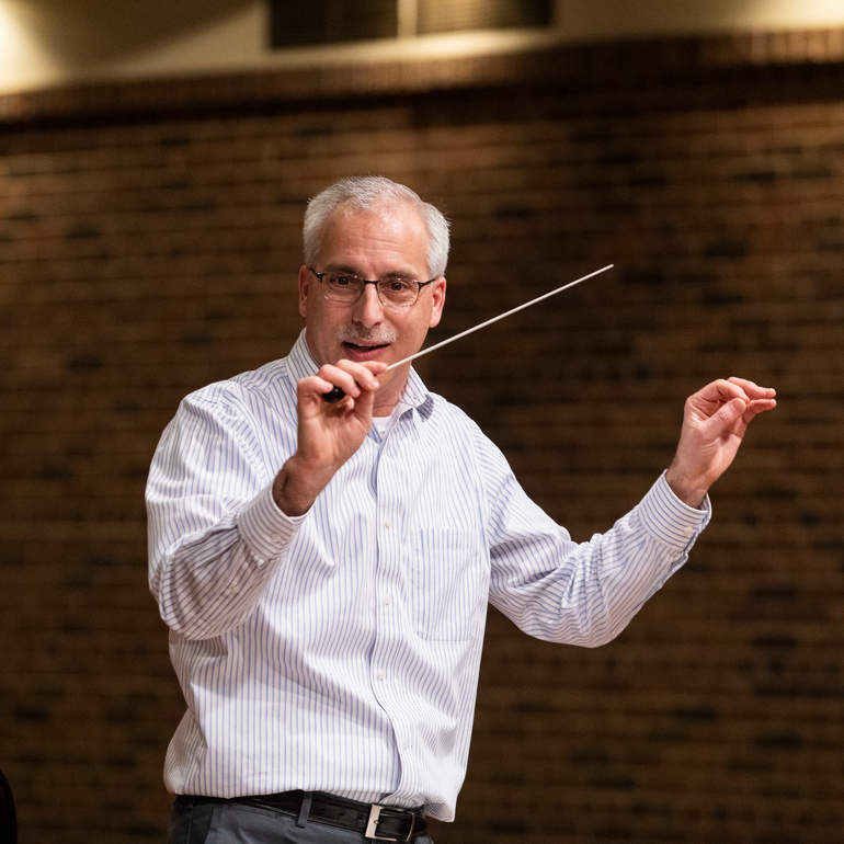 Douglas Orzolek conducts during a rehearsal.