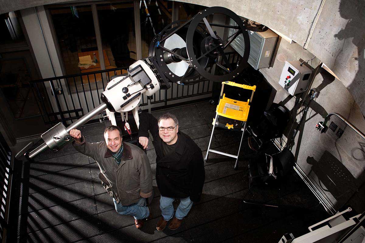 Physics professors Marty Johnston  and Gerry Ruch pose with the newly installed telescope