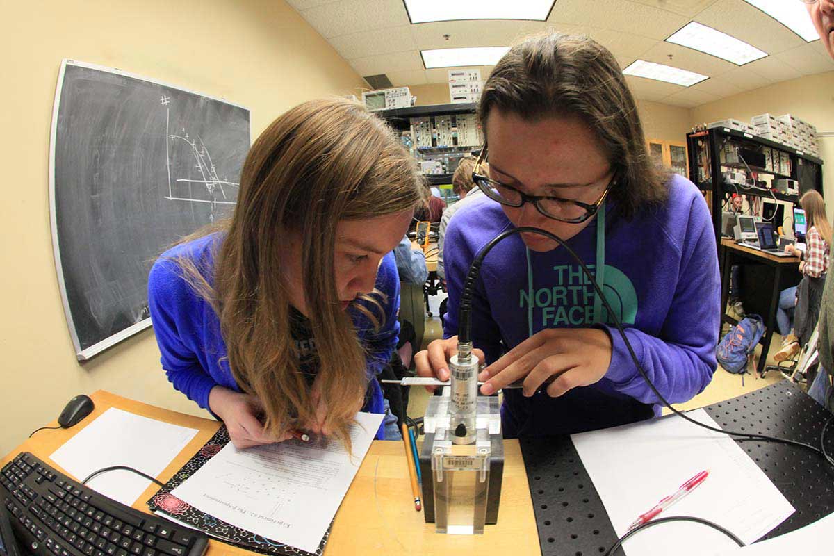 Two female physics students conducting an experiment in the lab.