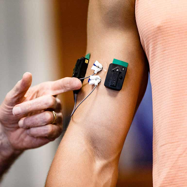 Sensors are attached to a student's bicep during a Health and Human Performance class.