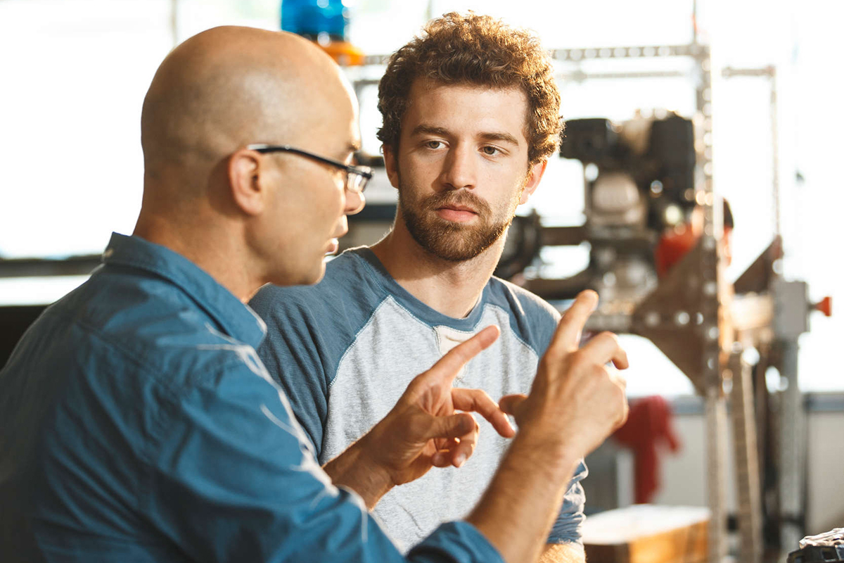 A faculty and student engage in conversation.