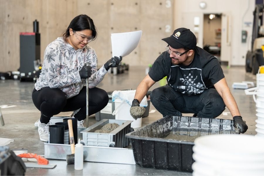 St. Thomas civil engineering students test the properties of concrete in a lab experiment.