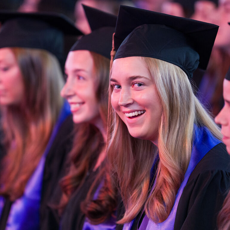 Female graduates watching the ceremony
