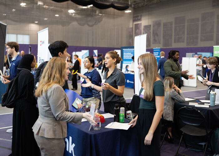 Student talking to a professional at a career fair