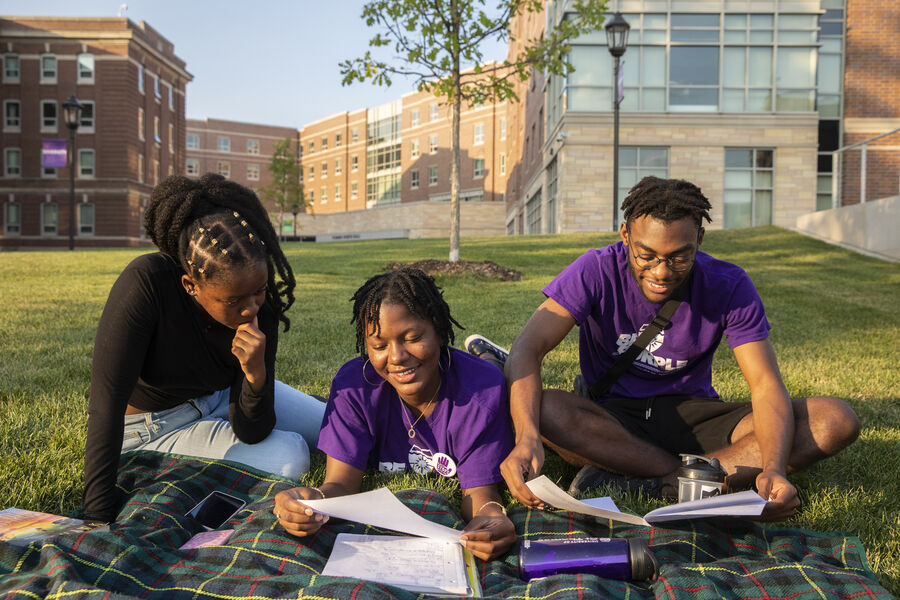 three students studying outside
