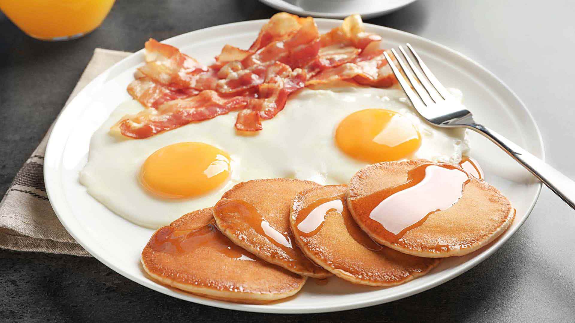 Plate of bacon eggs and pancakes
