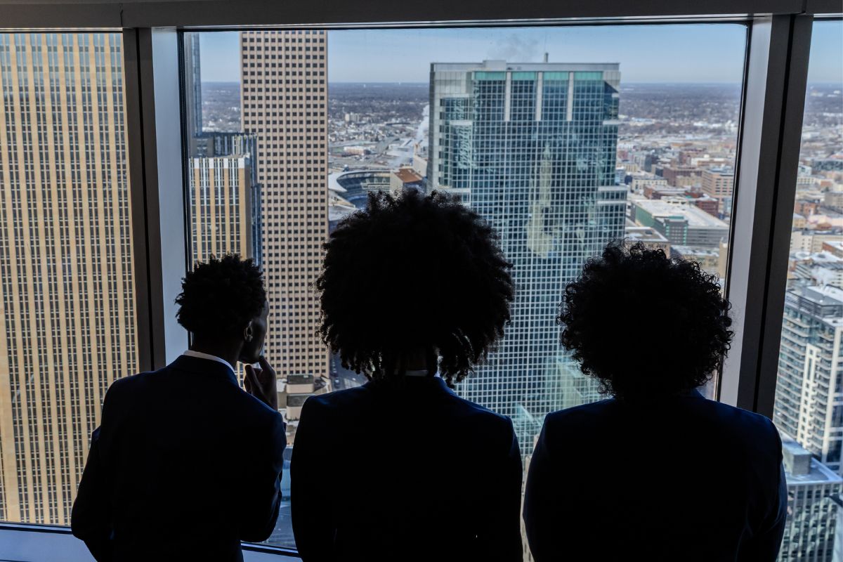 Three students overlooking the downtown Minneapolis skyline