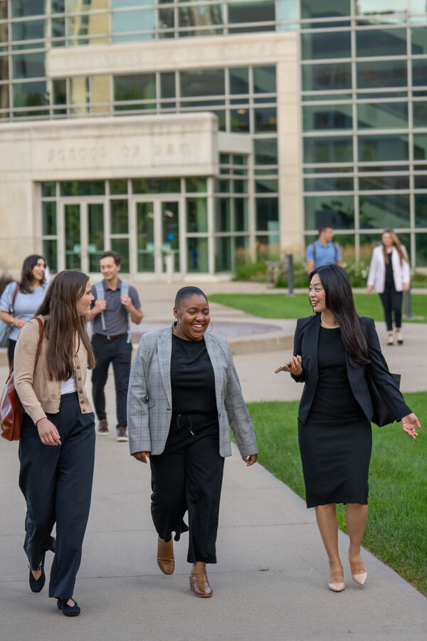 graduate students walk outside while talking