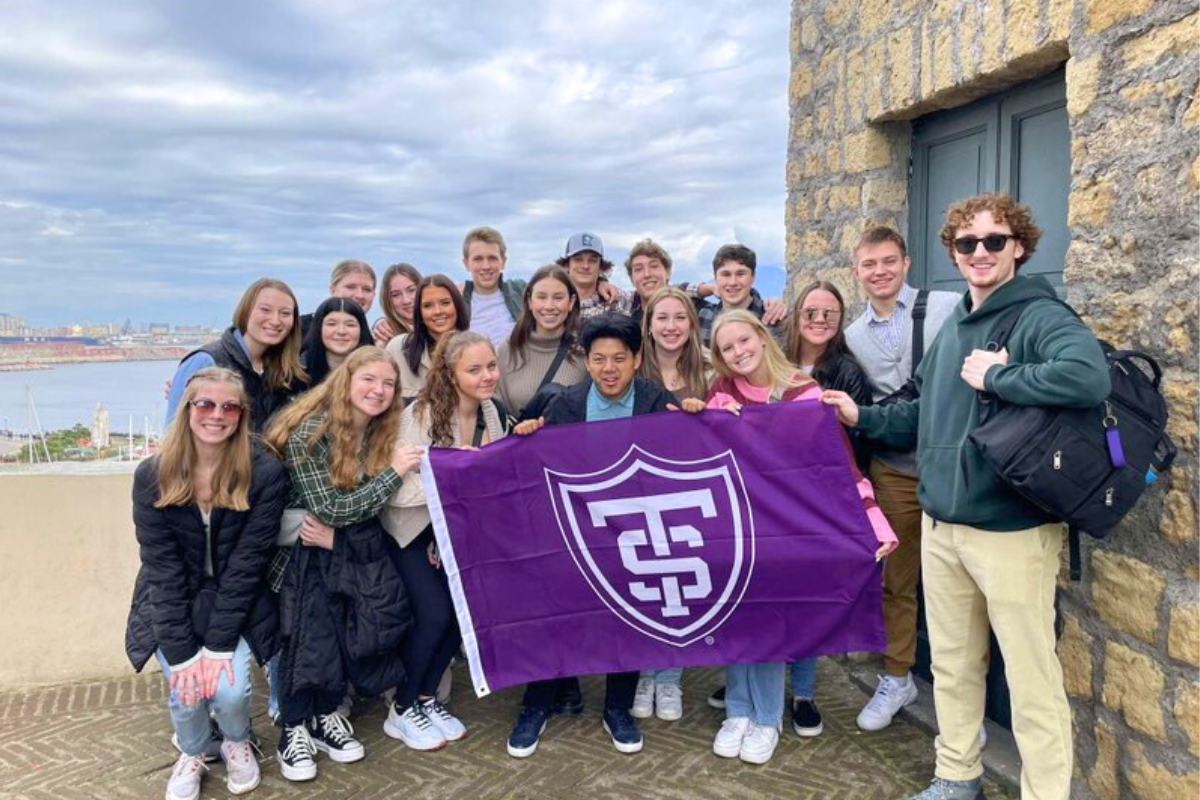 students with St. Thomas flag posing in Rome