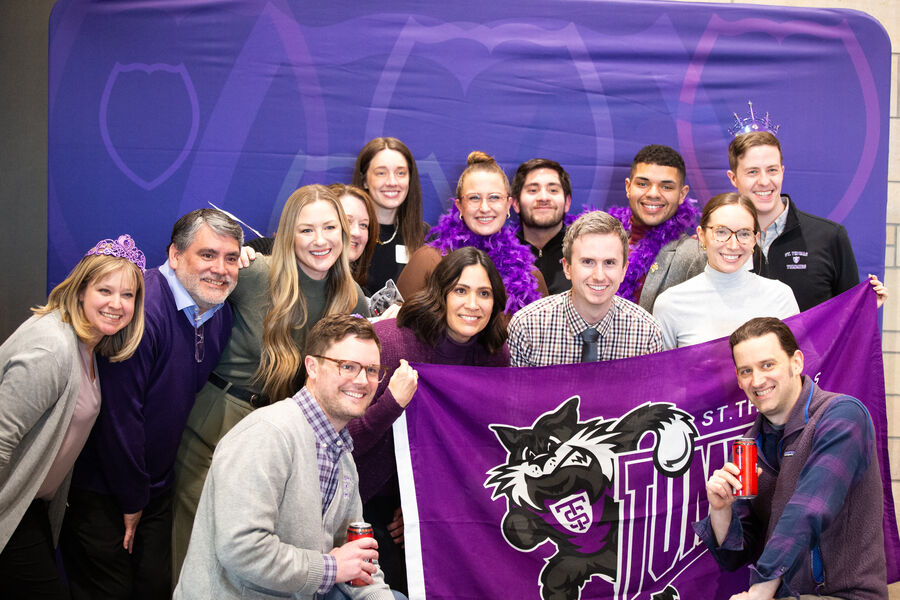 Staff pose with St. Thomas props