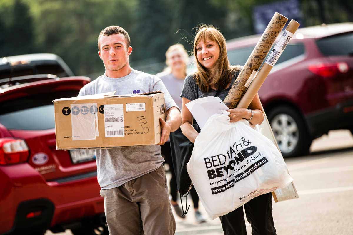 Volunteers help the family of a student move in.