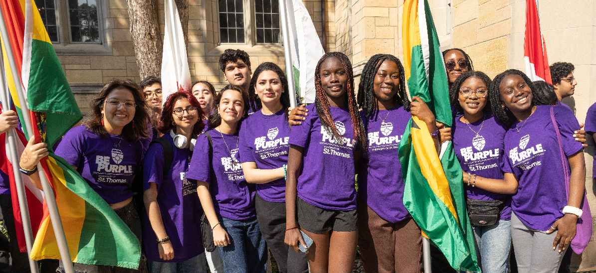 International students carrying flags during March through the Arches