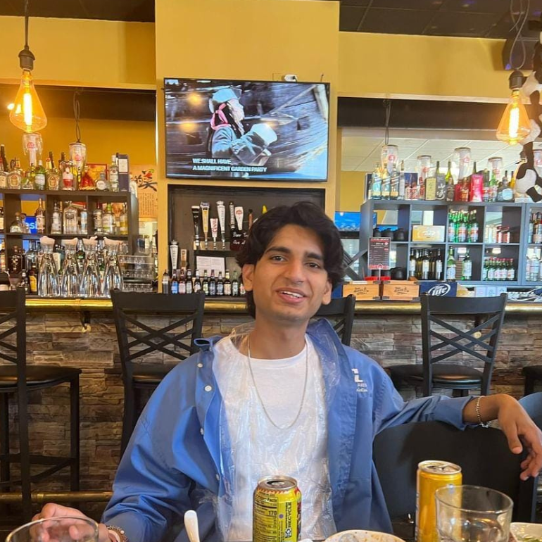 Young man sitting at a restaurant smiling