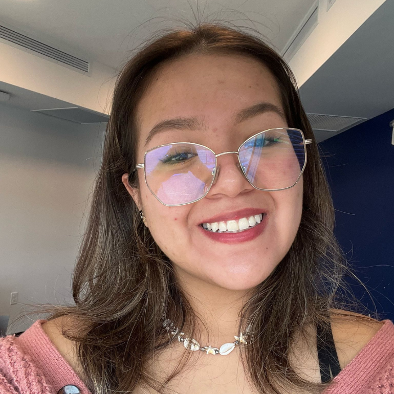 Young woman with glasses smiling.
