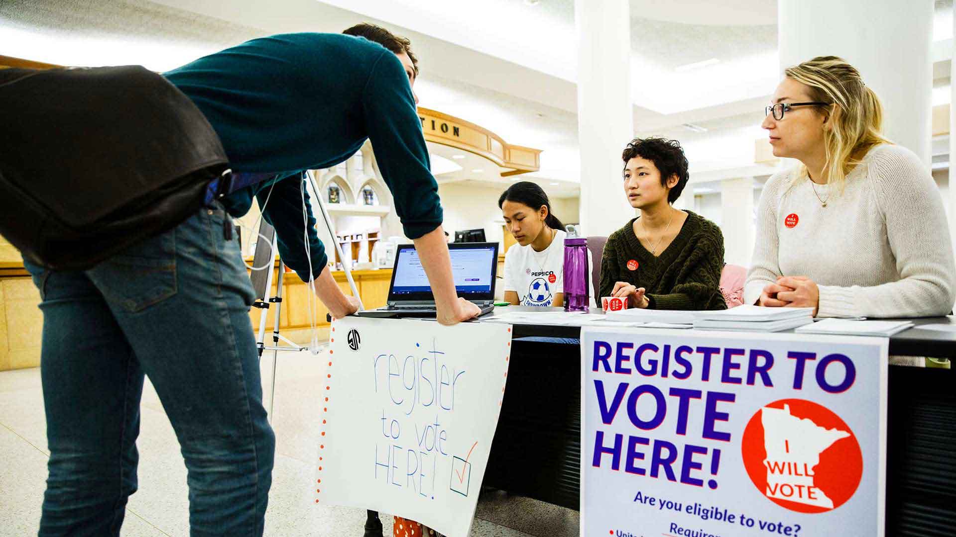 Students help a student register to vote
