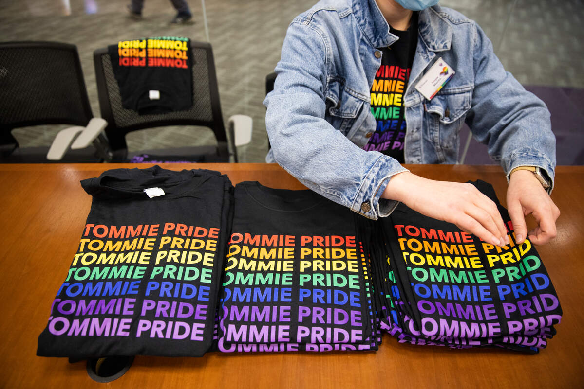 photo of a student handing out qmunity t-shirt