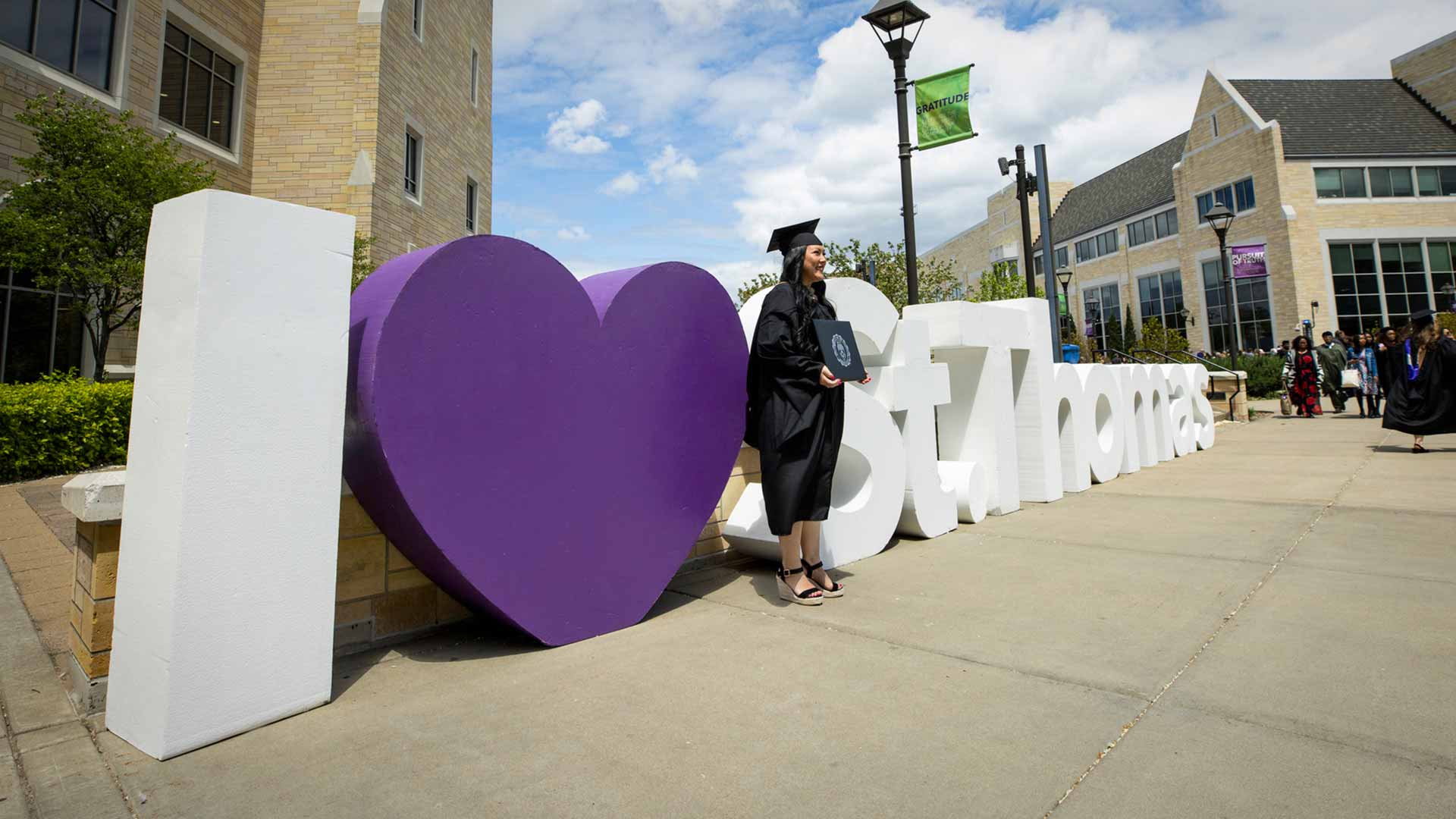 Graduate student standing next to giant letters