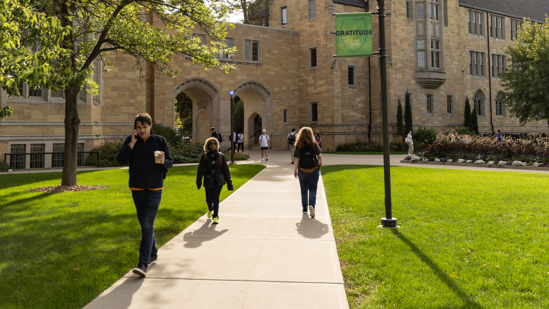 Students walking on campus with fall trees