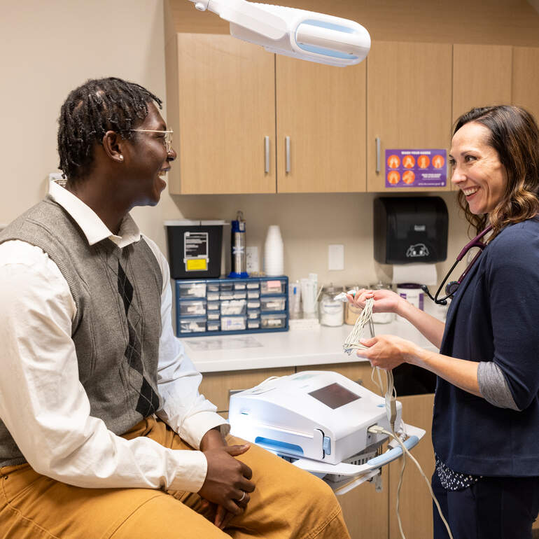 patient and nurse talking by medical equipment