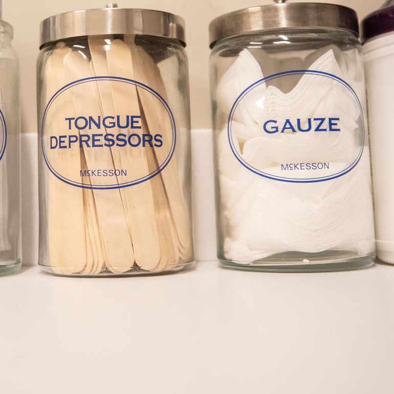 Tongue depressors and gauze jars filled with those items.