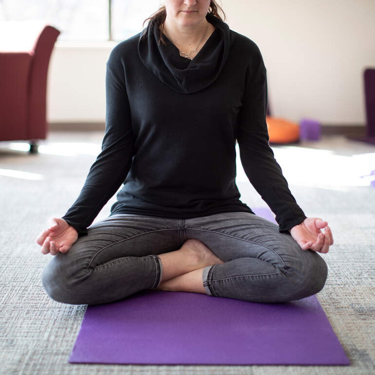 person mediating on yoga mat 