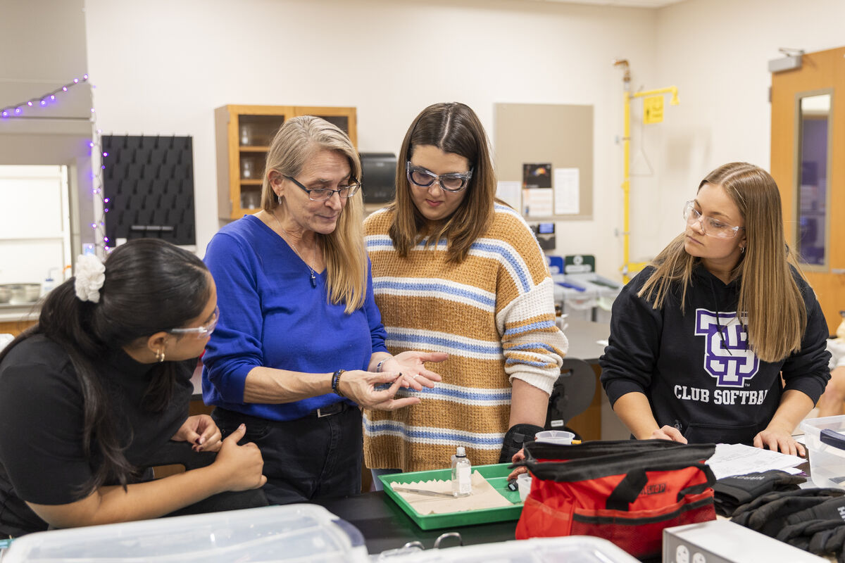 Students working with their professor in a classroom lab