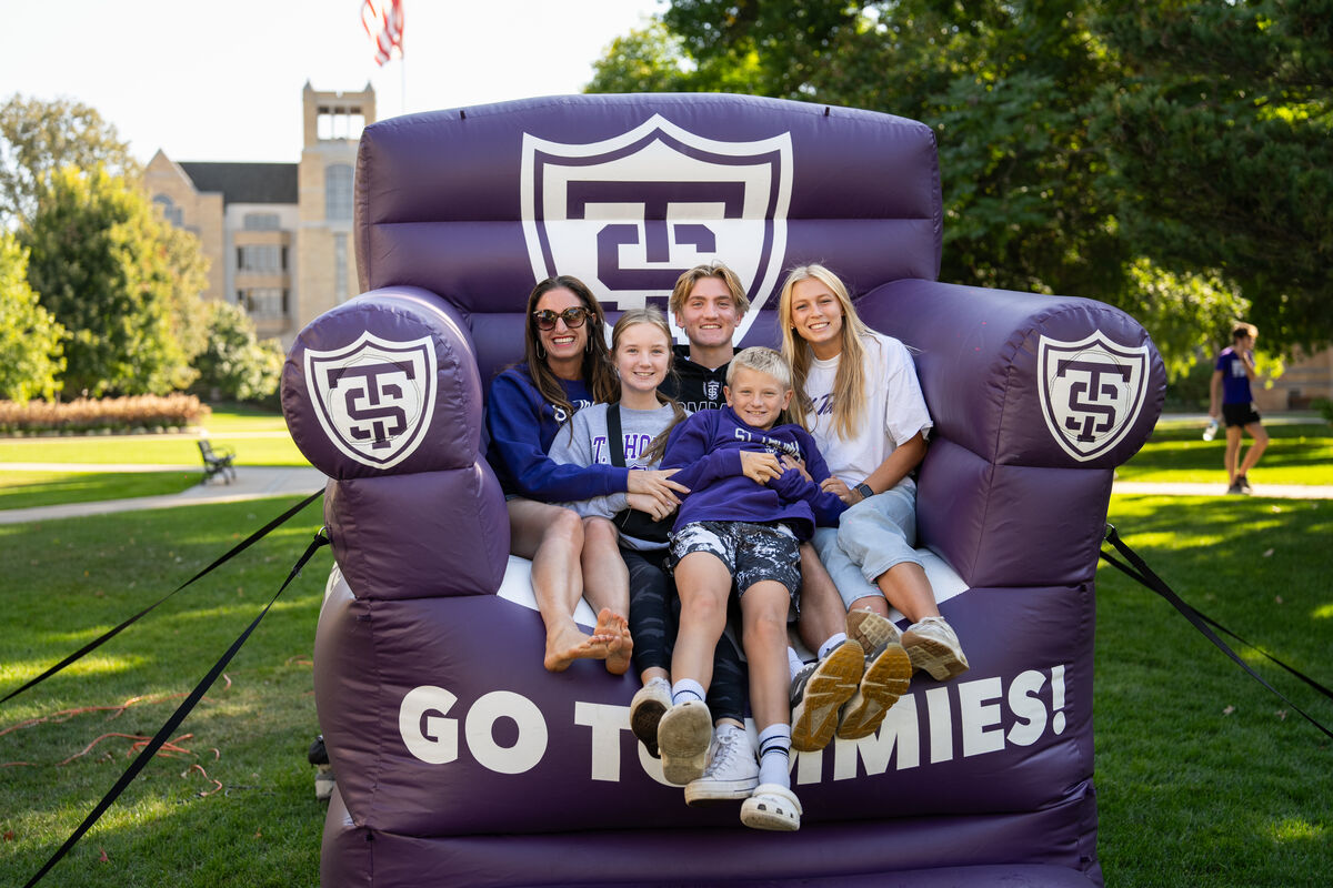 Family poses in a large inflatable chair